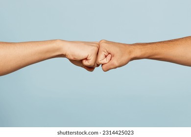 Close up shot of couple two male friends men together hold hands folded fist bump gesture isolated on pastel plain light blue cyan color background studio portrait. Friendship business greet concept - Powered by Shutterstock