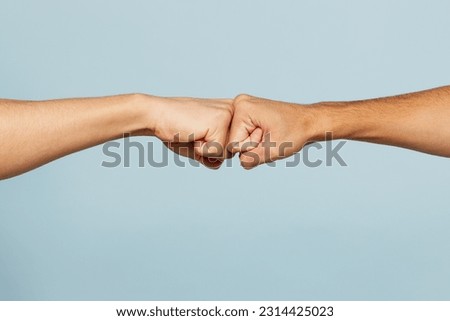 Close up shot of couple two male friends men together hold hands folded fist bump gesture isolated on pastel plain light blue cyan color background studio portrait. Friendship business greet concept
