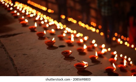 Close up shot of Dev Deepawali 2021 festival, Earthen lamps lit on the stairs leading to the Ganges with selective focus. 
Thousands of diyas (oil lamps) are lined up on the stairs near Ganges. - Shutterstock ID 2085698803