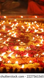 Close up shot of Dev Deepawali 2022 festival, Earthen lamps lit on the stairs leading to the Ganges with selective focus. Thousands of diyas (oil lamps) are lined up on the stairs near Ganges.