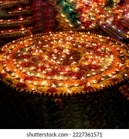 Close up shot of Dev Deepawali 2022 festival, Earthen lamps lit on the stairs leading to the Ganges with selective focus. Thousands of diyas (oil lamps) are lined up on the stairs near Ganges.