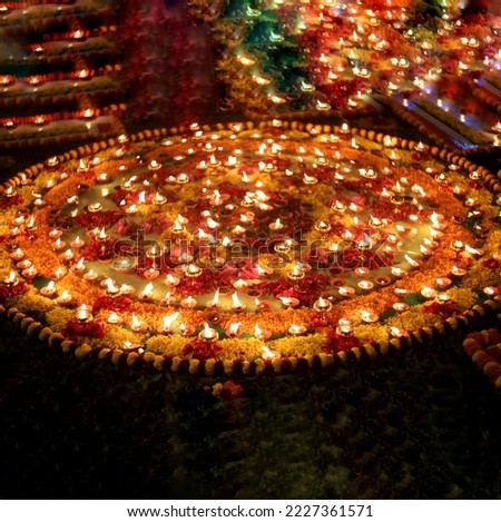 Close up shot of Dev Deepawali 2022 festival, Earthen lamps lit on the stairs leading to the Ganges with selective focus. Thousands of diyas (oil lamps) are lined up on the stairs near Ganges.