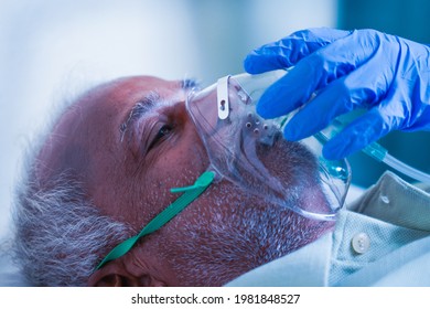 Close up shot, Doctor helping by adjusting ventilation oxygen mask to covid infected difficulty in breathing or breathlessness to patient at hospital - Concept of dyspnea due to coronavirus infection. - Powered by Shutterstock