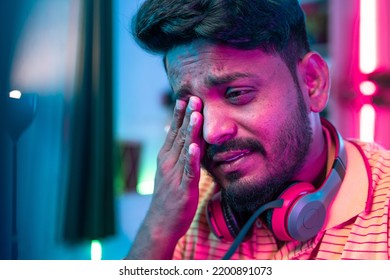 Close Up Shot Of Exhausted Or Tired Gamer Rubbing His Eyes While Playing Video Game During Late Night - Concept Of Gaming Addiction And Health Care