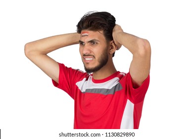 Close Shot Of Fan Is Disappointed Man With The Team Of His Country, With The Flag Of Egypt Makeup On His Face And A Red T-shirt, Putting Hands In The Head, Isolated On A White Background.