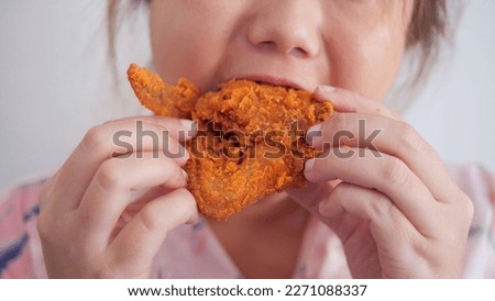 Close up shot of fat woman eating deep fried chicken, fast food. Enjoying unhealthy eating - junk food concept. Close up mouth eating