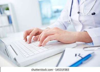 Close Shot Of A Female Doctor Studying Medical Records Via Laptop