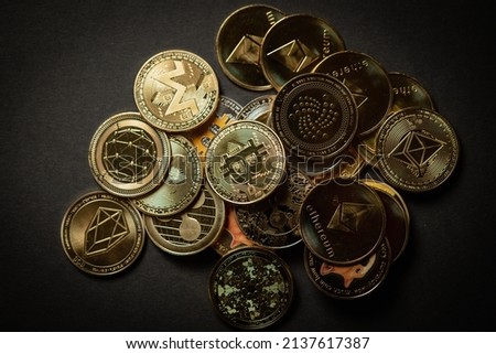 Close up shot of a golden Bitcoin in a stack, among other various digital cryptocurrencies .