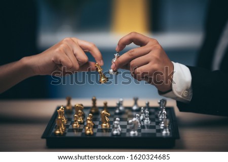 Close up shot golden chess to defeat killing silver king chess on white and black chess board for business challenge competition winner and loser concept, selective