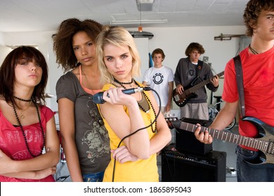 Close Up Shot Of A Group Of Teenagers Standing In A Garage Band And Looking Confidently At The Camera