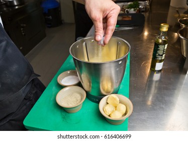 Close Up Shot Of A Hand Dropping Salt Into A Blender.