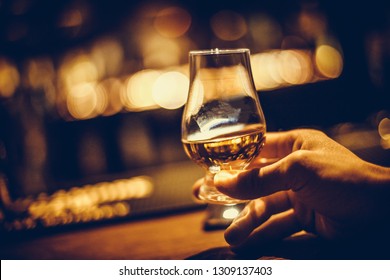 Close Up Shot Of A Hand Holding A Glencairn Single Malt Whisky Glass.