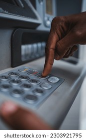 Close up shot of a hand using the ATM keyboard. He is checking his bank account.