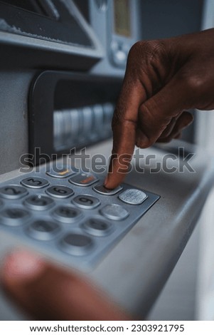 Close up shot of a hand using the ATM keyboard. He is checking his bank account.