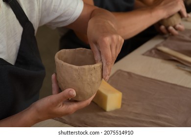 Close up shot of hands of crafts people, working with clay in pottery studio - Powered by Shutterstock