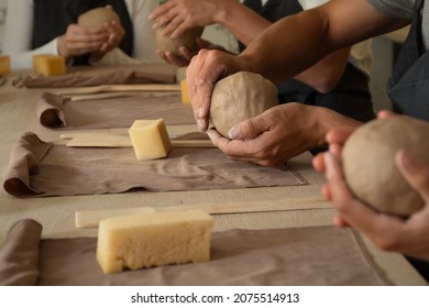 Close up shot of hands of crafts people, working with clay in pottery studio - Powered by Shutterstock