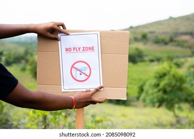 Close up shot of hands pasting No fly zone sign on board at drone Restricted area as safety regulations - concept of drone restricted area.