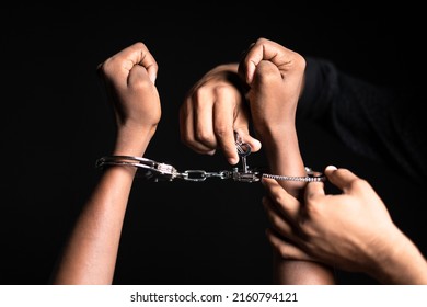 Close Up Shot Of Hands Removing Cuffs From Hand On Black Dark Background - Concept Of Freedom, Releasing And Liberty.