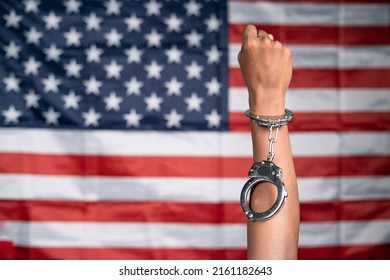 Close Up Shot Of Hands Rising With Released Cuffs Against Us Or American Flag As Background - Concept Of Juneteenth, Freedom And Justice.