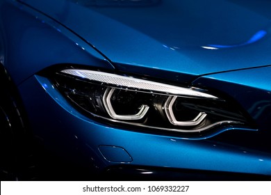 Close up shot of headlight in luxury 
blue car background. Modern and expensive sport car concept