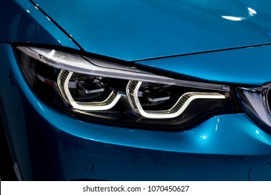 Close Up Shot Of Headlight In Luxury 
Blue Car Background. Modern And Expensive Sport Car Concept