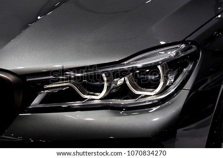 Close up shot of headlight in luxury 
grey car background. Modern and expensive sport car concept