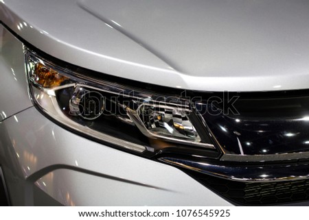 Close up shot of headlight in luxury 
silver car background. Modern and expensive sport car concept