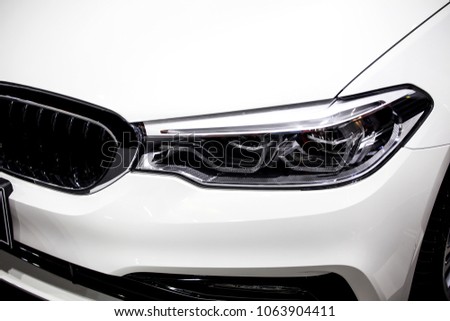 Close up shot of headlight in luxury 
white car background. Modern and expensive sport car concept