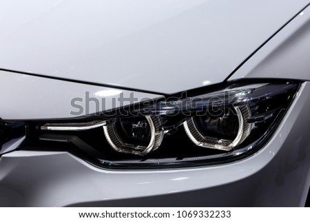 Close up shot of headlight in luxury 
white car background. Modern and expensive sport car concept