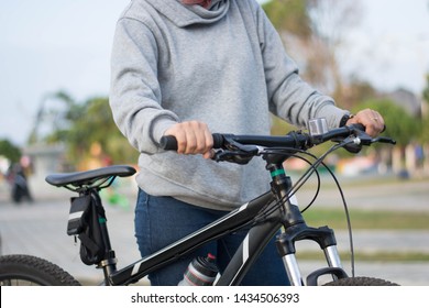 close up shot of hijab  woman's hand was holding the wheel of a bicycle in a park in the afternoon - Powered by Shutterstock