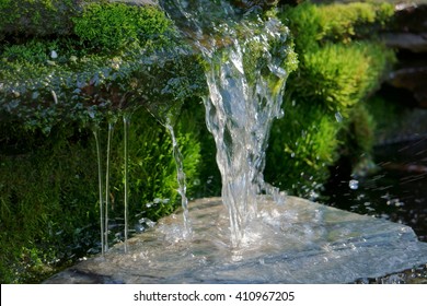 Close Up Shot Of A Homemade Waterfall In A Small Backyard Pond That Filters Water For A Koi Pond.