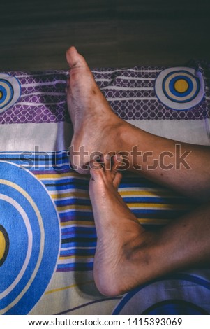 close up shot of human legs lying on bed in morning.