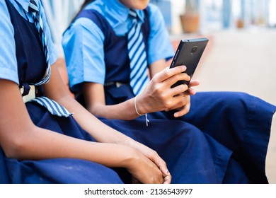 Close Up Shot Of Kids Hands Using Mobile Phone At School By Hiding- Concpet Of Smartphone Addiction, Using Social Media And Palying Games.