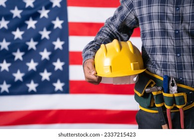 Close up shot of labour with tools or equipment by holding helmet in hand in front of USA flag - concept of maintence service, labour day and employment. - Powered by Shutterstock