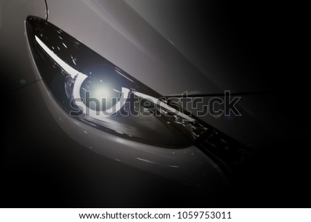 Close up shot of led headlight in luxury 
white car on black background with copy space. Modern and expensive sport car concept