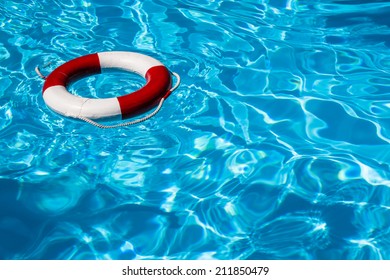 A Close Up Shot Of A Life Guards Red And White Rescue Ring Buoy Floating In A Pool.