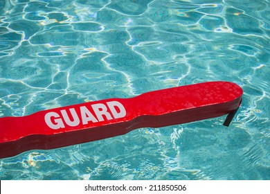 A close up shot of a life guards red rescue tube floating in a pool.