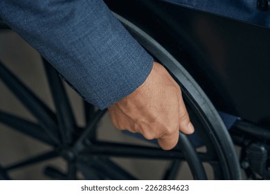 Close up shot of male hand on the wheel of wheelchair - Shutterstock ID 2262834623