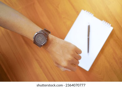 Close up shot of a man checking time on her watch
