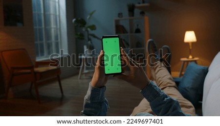 Close up shot of man holding a smartphone with chroma key mock up green screen - technology, connections, communications concept