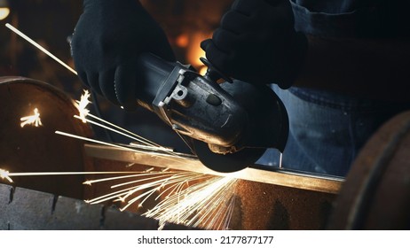 Close Up Shot Of Man Processing And Grinding Metal Barbecue Bbq Grill In Workwear And Protective Gloves In Equipped Garage Workshop