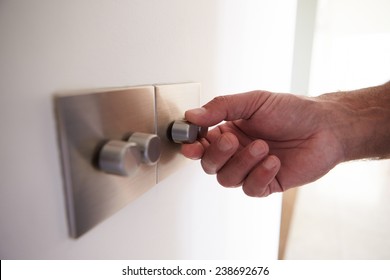 Close Up Shot Of Man Turning Down Electrical Dimmer Switch