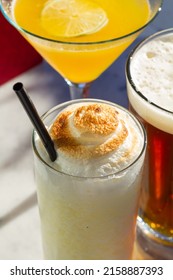 A Close Up Shot Of Mango Martini Sluchy Lemon Cocktail Amber Lager Beer Grouped Together On Marble Table