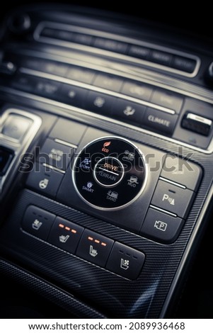 Close up shot of a modern car drive mode selector button, on the central console.