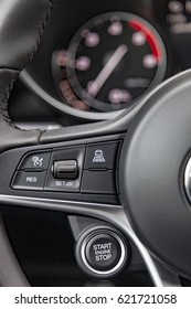 Close Up Shot Of Modern Car Steering Wheel With Radar Based Cruise Control Buttons And Formula 1 Style Engine Start/stop Button