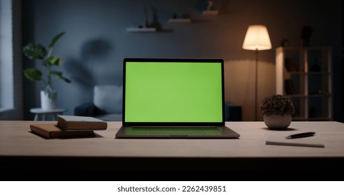 Close up shot of modern chroma key green screen laptop computer set up for work on desk at night - remote work, technology concept - Powered by Shutterstock