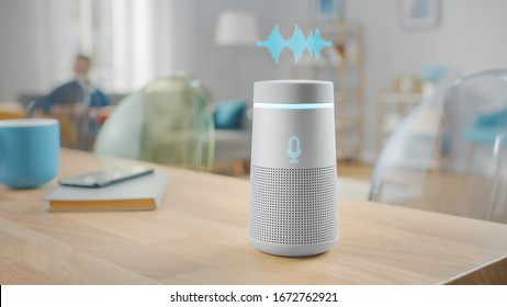 Close Up Shot of a Modern Silver Wireless Speaker Standing on a Table at Home with Voice Recording Hologram