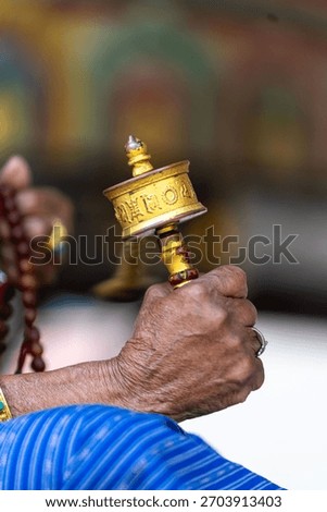 Close shot of a monk or devotee holding a golden ceremonial object in a religious ritual.