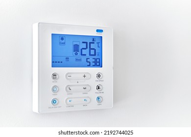 Close Up Shot Mounted On White Wall, Climate Control Show 26 Degrees Indoor, Remote Air-conditioner Inside Smart Home Close Up View, No People. Modern Tech, Comfort Life Concept