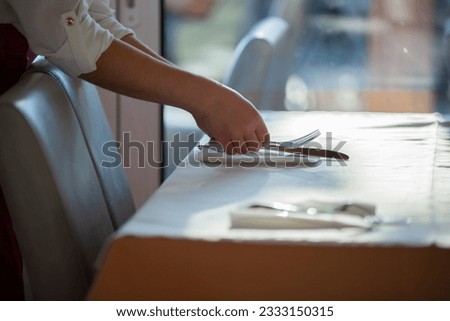 Close shot, no face for arranging tableware in restaurant by waiter